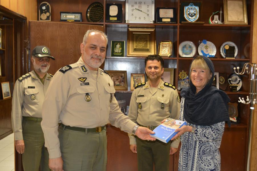 Dr Maria Dotsenko presents a book to Second Brigadier General Dr Hossein Valivand-Zamani